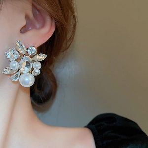 Gros plan de boucles d'oreilles perles et cristaux portées par un mannequin