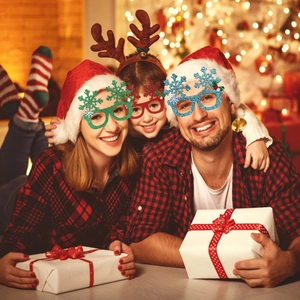 Family wearing glittery snowflake Christmas party glasses in a cozy holiday home setting