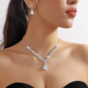 Close-up of a model wearing a sparkling crystal waterdrop necklace and earrings set
