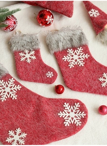 Close-up of red Christmas stockings with white snowflake appliques and grey faux fur trim