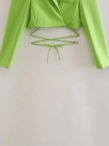Detail of bright green cropped wrap blazer with cross tie design and woven texture