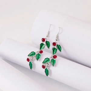 Christmas drop earrings with green enamel leaves and red rhinestone berries on white background