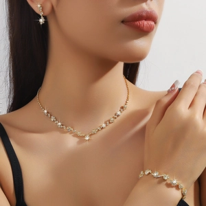 Dettaglio di elegante set dorato con collana, orecchini e bracciale con inserti in cristallo