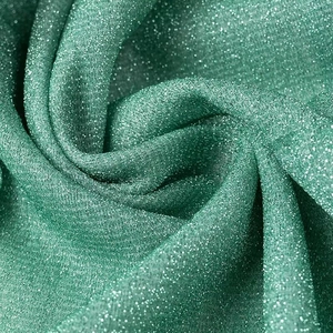 Détail macro du tissu lurex vert scintillant avec textures fines et plis naturels
