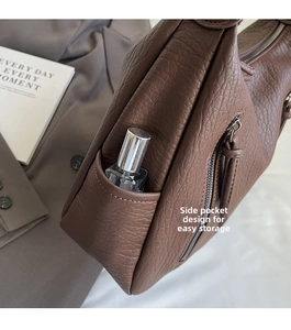 Close-up of brown lychee texture leather shoulder bag with functional side pocket