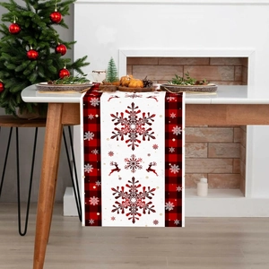 Christmas table runner with red and black plaid snowflake pattern on a wooden table decoration