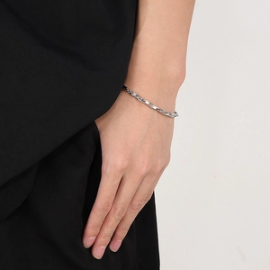 Gros plan détaillé du bracelet Mobius en acier titane sur le poignet d'un mannequin homme