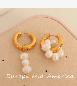 Détail macro de boucles d'oreilles créoles dorées vintage avec perles blanches