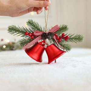 Weihnachtsbaum-Deko mit roten Metallglocken, Tannennadeln und rot gestreifter Schleife