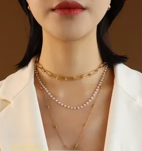 Three-layer gold titanium steel necklace featuring pearls and queen pendant on a model