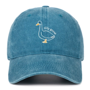 Detailed close-up of cartoon goose embroidery on blue washed cotton baseball cap