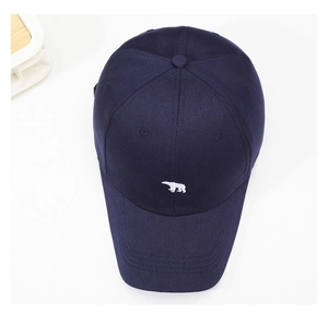 Detail of navy blue cotton baseball cap featuring high-quality white polar bear embroidery