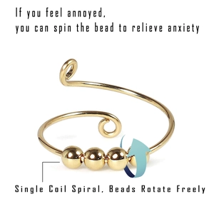 Detail view of gold fidget ring with four rotating beads for anxiety relief