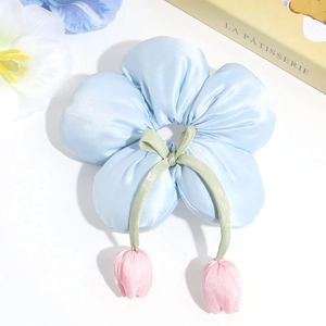 Detail of light blue floral scrunchie with pink tulip charms and satin texture