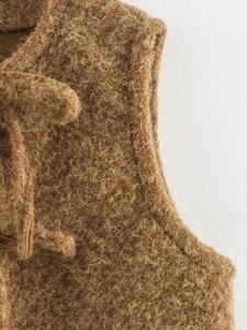 Close-up of textured brown mohair wool blend fabric on a casual tie-waist vest top