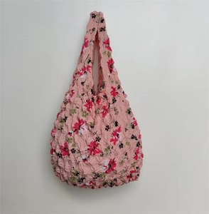 Detail of pink floral pleated bubble bag with red and white flower pattern and textured fabric