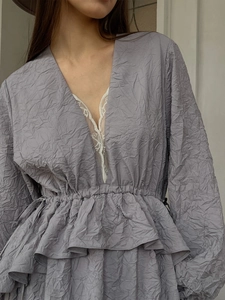 Robe plissée lavande avec décolleté en V profond et détails en dentelle blanche