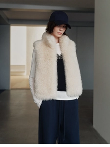 Close-up of fluffy off-white faux fox fur texture on a luxury cashmere vest