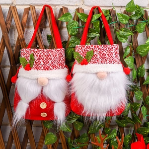 Hanging faceless Santa gnome gift bags on wooden fence with festive holiday decorations