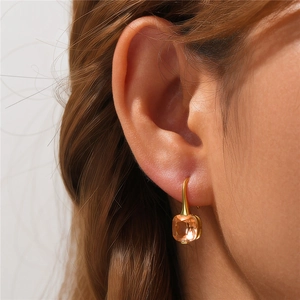 Detail of S925 silver champagne square zircon drop earrings on a model ear