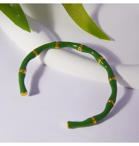 Detail of bamboo-style cuff bracelet with green enamel and gold plated stainless steel