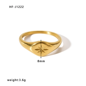 Close-up of golden signet ring featuring an engraved eight-pointed star on a flat disc