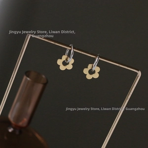 Detail of daisy flower earrings featuring silver hoops and gold petal charms