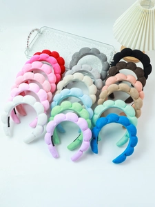 Flat lay of colorful braided velvet headbands and wristbands on a decorative tray