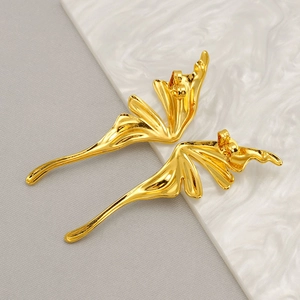 Detail of high-polished golden butterfly wing stud earrings with sleek 3D wave design