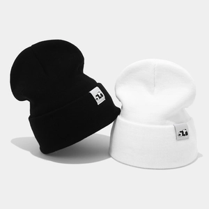 Winter knitted beanies in black and white with cute panda labels for warmth and style