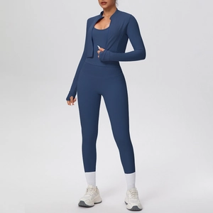 Dettaglio del set yoga blu in tre pezzi con giacca slim, fori per pollici e vita alta