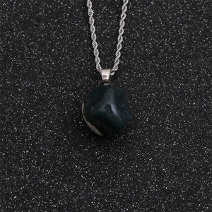 Detail of silver twist chain with smooth dark green natural stone pendant on star background
