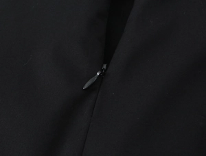 Close-up of invisible zipper closure on high-quality black fabric sleeveless dress
