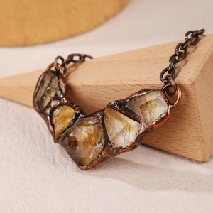 Detailed macro shot of vintage raw citrine stones set in antique copper casing on wood