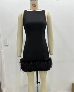 Détail de la robe courte noire chic avec une bordure en plumes denses sur l'ourlet