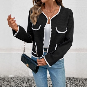 Close-up of black waffle texture jacket with white scalloped trim and button details