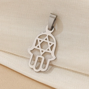 Macro shot of silver stainless steel Hamsa hand pendant with cutout Star of David design