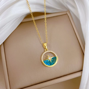 Macro shot of gold-plated starburst necklace with blue gem and diamonds in a jewelry box