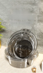 Close-up of stackable transparent plastic washbasin showing thick PET material and side handles