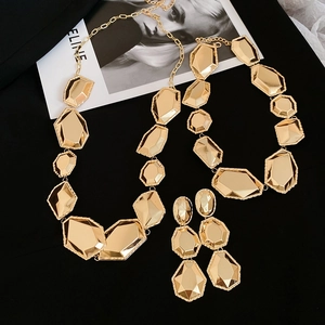 Vue détaillée d'une parure de bijoux géométriques dorés avec collier et boucles