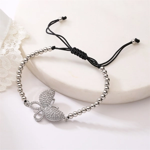 Detail of adjustable black cord bracelet featuring a shimmering zircon butterfly charm