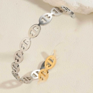 Detail of two-tone gold and silver anchor link design on adjustable open bangle bracelet