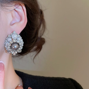 Detail view of retro vintage pearl earrings with crystals on a female model