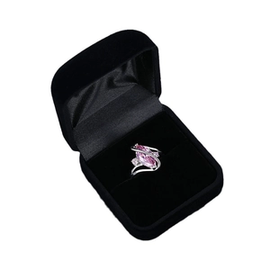Pink marquise cut gemstone ring on silver band inside a black velvet jewelry box