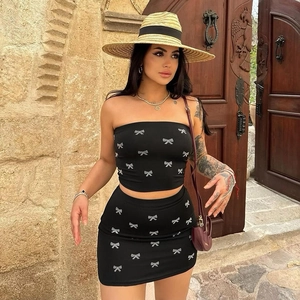 Detail of black two-piece set featuring white bow prints on tube top and mini skirt