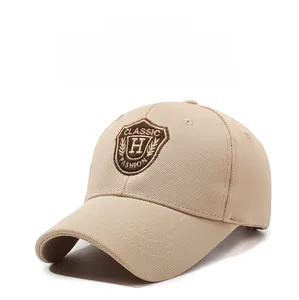 Détail d'une casquette beige avec broderie de bouclier et œillets de ventilation