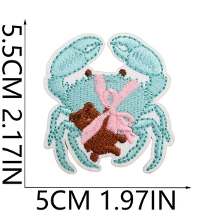 Detail of embroidered blue crab patch with teddy bear and dimension markings