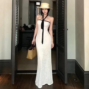 Détail d'une robe maxi blanche à licou avec des liens noirs contrastés pour un style de plage