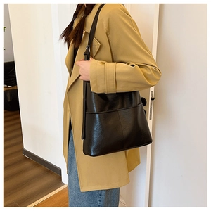 Gros plan d'un grand sac cabas en cuir noir porté épaule montrant sa texture lisse