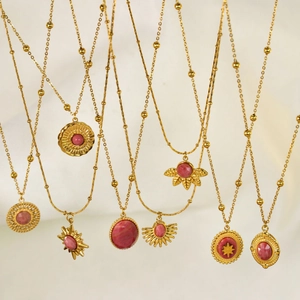 Detailed view of bohemian style gold plated necklaces with pink rhodochrosite pendants